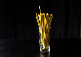Lots of yellow tubes in a glass on a black background.
