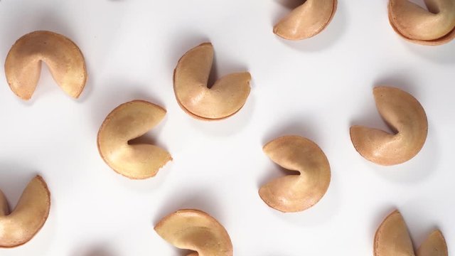 Top down view of Chinese cookies rotate on a white background. Traditional fortune cookie. Nice view on spinning biscuit crispy sweet cookie. shadow dance