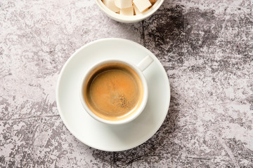Cup of americano coffee with pancakes and sour cream cake for breakfast. A cup of black coffee in a white cup, shot from above, with copyspace. Food and drink concept.
