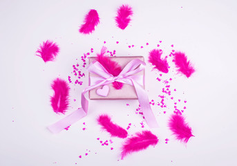Fototapeta na wymiar A beautiful festive box with a gift, with bright feathers and hearts. Celebration.