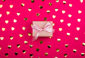 Beautiful gift box with satin ribbon of delicate pink color, with golden confetti.