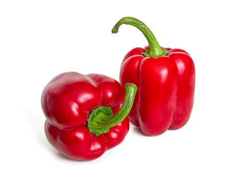 Two bright red sweet bell peppers on a white background
