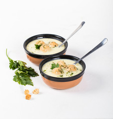 Cheese soup with chicken meatballs and dill and parsley in a bowl