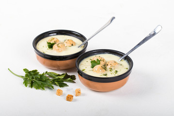 Cheese soup with chicken meatballs and dill and parsley in a bowl