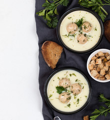 Cheese soup with chicken meatballs and dill and parsley in a bowl