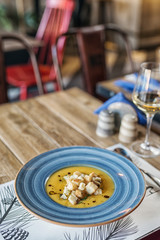 broth served in a modern blue plate with beard