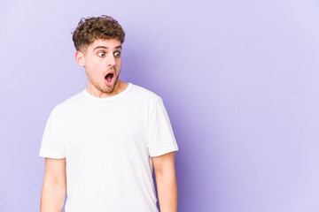 Young blond curly hair caucasian man isolated being shocked because of something she has seen.