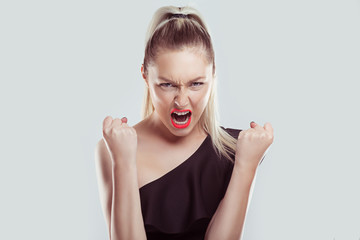 Closeup portrait head shot angry young woman having nervous breakdown screaming isolated white wall...