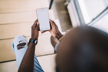 African American male using smartphone in room