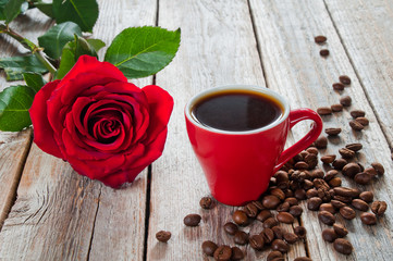 Cup of coffee and red rose on wooden table