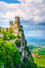 Fototapeta na wymiar San Marino, medieval tower on a rocky cliff and panoramic view of Romagna