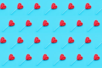 Seamless pattern. Valentines Day bckground. Lollipop candy hearts on blue background. Top view.