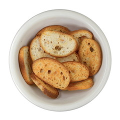 Sliced bruschetta in a white bowl on white background. Crusty bread bruschetta.