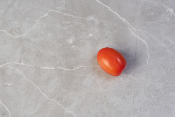 red tomato on a tile background