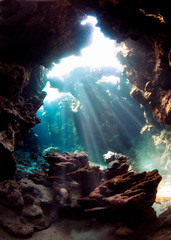 Underwater world. A cave under water permeated with rays of sunlight.
