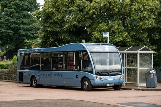 Blue Optare Solo 9.2 ecological bus of Garelochhead Coaches company at a bus stop waiting for commuting passengers