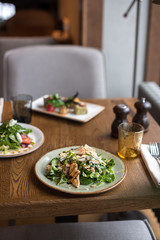 Grilled Chicken and Spinach Salad Garnished with Cheese and Almond. Lunch Served in Cafe