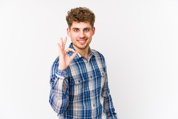 Young blond curly hair caucasian man isolated cheerful and confident showing ok gesture.