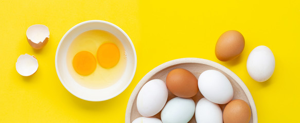 Fresh eggs on yellow background.