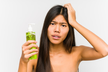 Young chinese woman holding a moisturizer with aloe vera isolated being shocked, she has remembered important meeting.