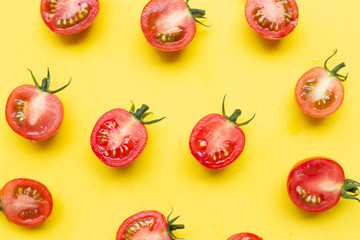 Fresh tomatoes, whole and half cut isolated on yellow background.