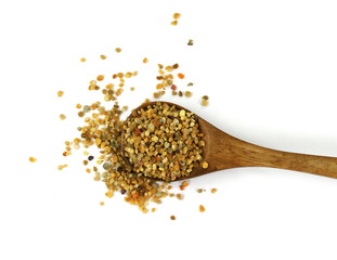 Pile of bee pollen in a wooden spoon isolated on white.