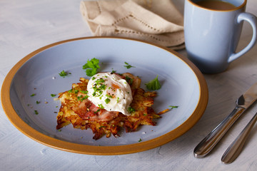 Potato cakes with topping: bacon and poached egg. Vegetable fritters, pancakes