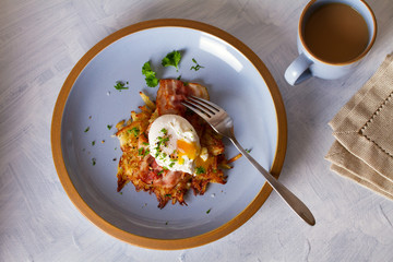 Potato cakes with topping: bacon and poached egg. Vegetable fritters, pancakes. View from above, top view