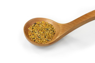 Pile of bee pollen in a wooden spoon isolated on white.