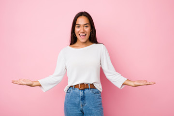 Young mixed race indian woman showing a welcome expression.