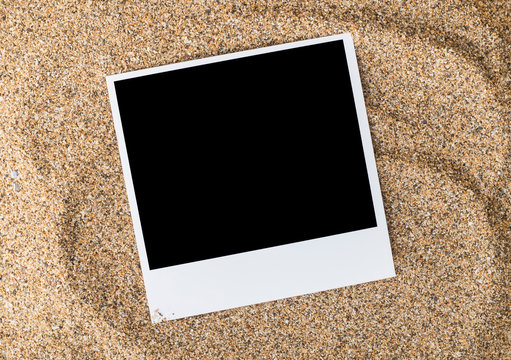 a polaroid photo on sand