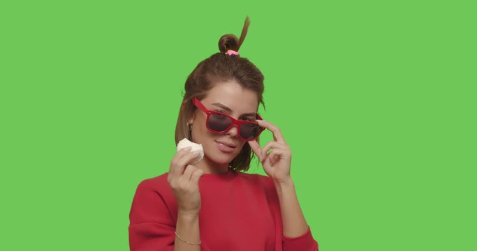 woman in sunglasses bites marshmallow