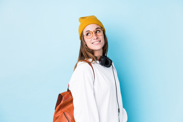 Young student woman isolated looks aside smiling, cheerful and pleasant.