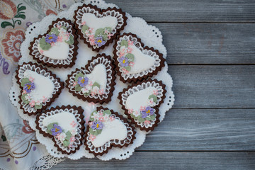 Heart shaped chocolate cookies decorated with royal icing glaze and flowers