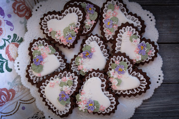 Heart shaped chocolate cookies decorated with royal icing glaze and flowers