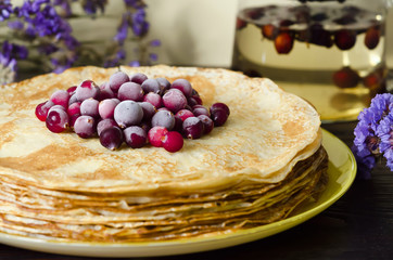 stack of thin pancake with cranberries and powdered sugar closeup. soft focus. national Russian holiday, tradition, Shrovetide
