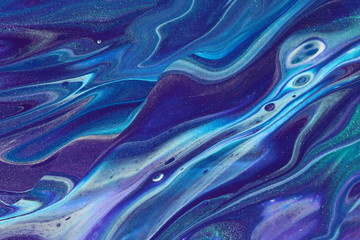 Rolling ocean waves of purple, bue, and metallic teal flow across the canvas in this abstract pour painting for backgrounds.