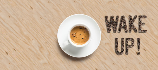 cup of coffee and text WAKE UP! on wooden background