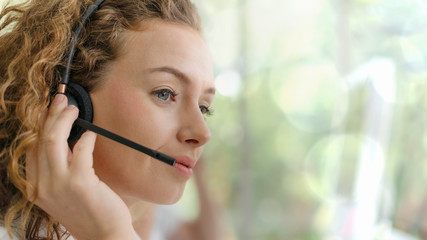business background of caucasian female customer service agent on telephone service to customers at...