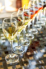 Wine tasting set in the light summer environment. Custom wine tasting concept. Glasses of wine on the glass table and outdoor background