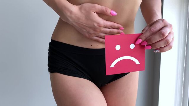 Woman Health. Female Body Holding Sad Smiley Card Near Stomach