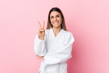 Young karate woman showing number two with fingers. © Asier