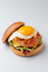 Hot mouthwatering burger with sunny side up egg isolated on white
