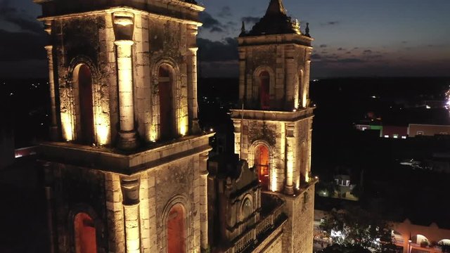 Extreme closeup aerial ascent at night of the towers of the Catedral de San Gervasio in Valladolid, Yucatan, Mexico.