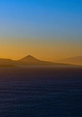 Naklejka na ściany i meble Vertical panoramic image of spectacular sky colors and sunset landscape of a volcanic island.