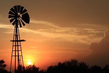 Bright Colorful Kansas Sunset with clouds and a Windmill silhouette