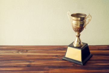 champion golden trophy on wood table with copy space ready for your design.