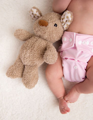 Little girl with teddy bear and cloth diaper