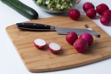 radish lies on a cutting board, next to a knife, cooking salad, cooking okroshka