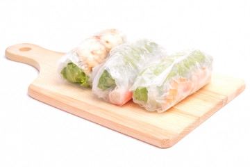 High key photo of Gỏi cuốn  or Vietnamese spring roll on wooden board. Traditional Vietnamese consisting of meat, prawn, vegetables, rice vermicelli and other ingredients wrapped in rice paper.